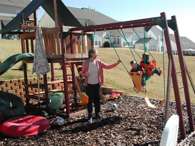 Gina pushing Kevin and Ryan on the swing
