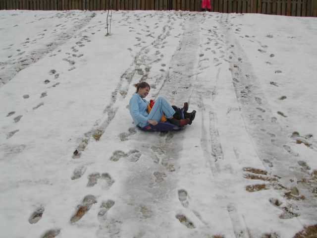 Dani and one of the kids sledding down the hill in the backyard during the 2007 Greenville snow